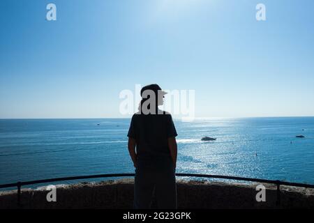 Paysage nature pittoresque silhouette féminine en chapeau contre paysage marin par temps ensoleillé. Belle mer méditerranée en été ensoleillé. Tourisme en vacances d'été. Photo de haute qualité Banque D'Images