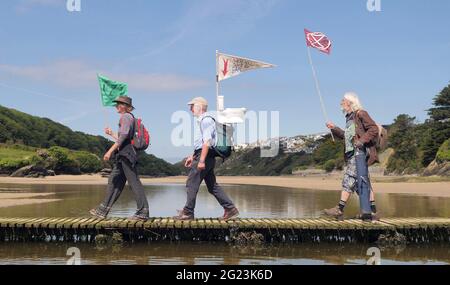 Newquay UK, Gannel River, Christian Climate action Group débute un pèlerinage de quatre jours à pied à la conférence du G7 de la baie Carbis pour protester contre le changement climatique. En partant de Newquay, ils traversent la rivière Gannel vers Crantock. La police du G7 intervient et conseille les marcheurs. Camping sur le chemin ils suivront les anciennes routes de pèlerinage chrétien . 8 juin 2021. Crédit : Robert Taylor/Alay Live News Banque D'Images