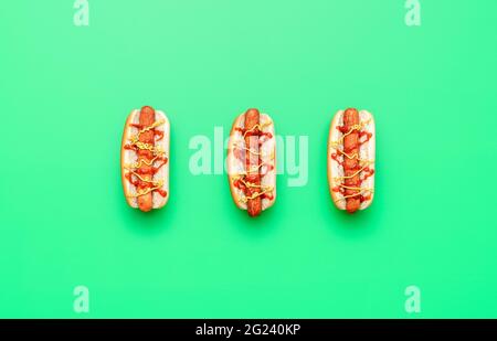 Vue ci-dessus avec 3 hot dogs isolés sur un fond vert. Délicieux hot dog avec ketchup et moutarde. Banque D'Images
