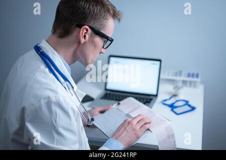 Sujet de la vérification rapide de la maladie cardiaque. Maladie cardiaque infarctus du myocarde. Médecin analysant l'électrocardiogramme au bureau de l'hôpital Banque D'Images