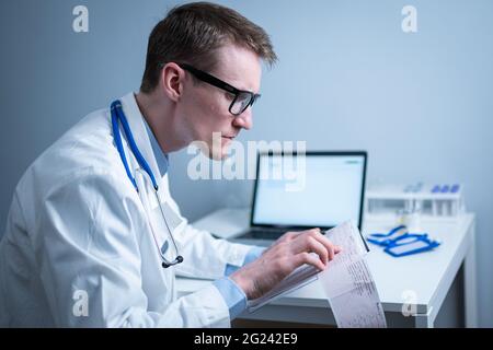 Sujet de la vérification rapide de la maladie cardiaque. Maladie cardiaque infarctus du myocarde. Médecin analysant l'électrocardiogramme au bureau de l'hôpital Banque D'Images