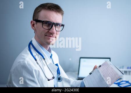 Sujet de la vérification rapide de la maladie cardiaque. Maladie cardiaque infarctus du myocarde. Médecin analysant l'électrocardiogramme au bureau de l'hôpital Banque D'Images