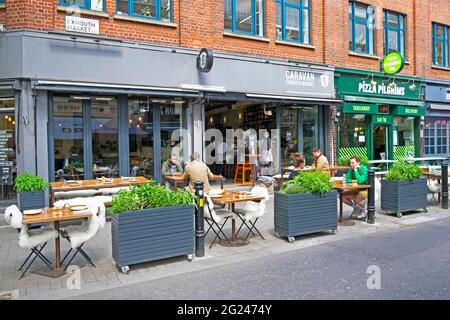 Personnes assises à des tables devant le restaurant Caravan à Exmouth Market Street à Clerkenwell social distancing à Londres EC1 Angleterre KATHY DEWITT Banque D'Images