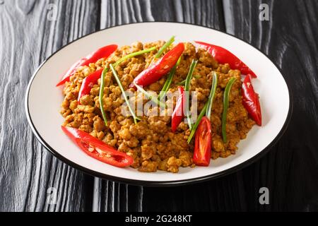 Porc épicé de style traditionnel thaïlandais au style traditionnel du sud avec pâte de cari jaune Khua Kling en thaï gros plan dans l'assiette sur la table. Horizontale Banque D'Images