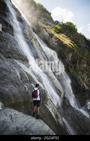 Russie, Karachay-Cherkessia, Arkhyz, Homme près de la chute d'eau Sofiyskiye Vodopady dans les montagnes du Caucase Banque D'Images