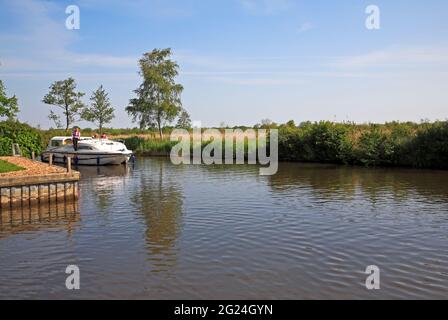 Un croiseur sur la rivière Ant sur les Norfolk Broads se préparant à s'amarrer à Irstead Staithe à Irstead, Norfolk, Angleterre, Royaume-Uni. Banque D'Images