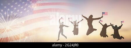 Silhouettes groupe de personnes tenant le drapeau des Etats-Unis saut en Amérique célébrer le 4 juillet feux d'artifice. Des drapeaux américains au coucher du soleil. Foule Banque D'Images