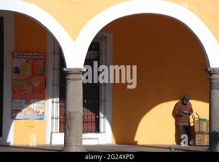 Homme debout sous les arches à Cholula, Puebla. Banque D'Images