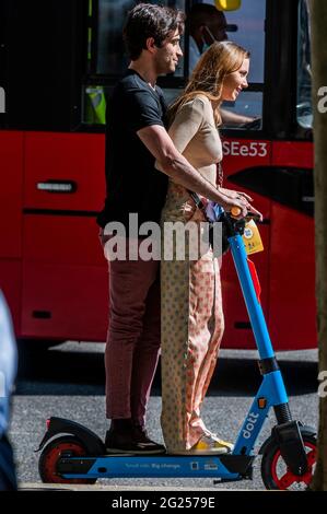 Londres, Royaume-Uni. 8 juin 2021. Beaucoup semblent trouver le processus de déverrouillage assez difficile, mais une fois qu'ils se mettent en marche, ils semblent assez heureux - les scooters électriques (e-scooters) sont maintenant disponibles à louer dans un petit nombre de quartiers de Londres. C'est la seule façon de conduire légalement un e-scooter sur la voie publique ou dans d'autres lieux publics de Londres. La location de trottinettes électroniques est assurée par trois opérateurs différents : Dott, Lime et TIER. Pour louer un e-trottinette, les utilisateurs doivent : télécharger l'application de l'opérateur choisi, terminer le processus d'inscription, y compris vérifier votre âge et votre permis de conduire, et remplir la commande Banque D'Images