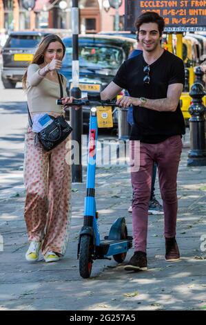 Londres, Royaume-Uni. 8 juin 2021. Beaucoup semblent trouver le processus de déverrouillage assez difficile, mais une fois qu'ils se mettent en marche, ils semblent assez heureux - les scooters électriques (e-scooters) sont maintenant disponibles à louer dans un petit nombre de quartiers de Londres. C'est la seule façon de conduire légalement un e-scooter sur la voie publique ou dans d'autres lieux publics de Londres. La location de trottinettes électroniques est assurée par trois opérateurs différents : Dott, Lime et TIER. Pour louer un e-trottinette, les utilisateurs doivent : télécharger l'application de l'opérateur choisi, terminer le processus d'inscription, y compris vérifier votre âge et votre permis de conduire, et remplir la commande Banque D'Images