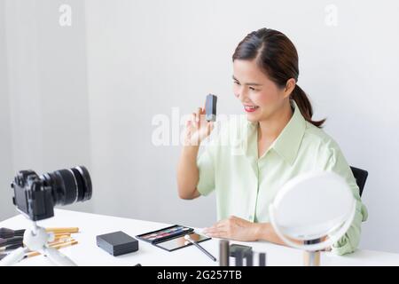 Une blogueuse travaillant sur la caméra filmant comment faire des tutoriels de maquillage à porter sur soi et à la mode. Banque D'Images