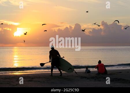 Miami-Sunny Isles-USA- 2-01-2016- Un homme marche avec sa planche de surf dans l'eau sur Sunny Isles Beach. © JOSE ISAAC BULA URRUITA. Banque D'Images