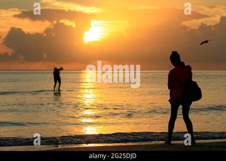 Miami-Sunny Isles-USA- 2-01-2016- Une mère marche avec son fils dans ses bras à l'aube sur la plage Sunny Isles. © JOSE ISAAC BULA URRUITA. Banque D'Images