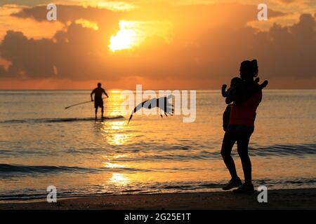 Miami-Sunny Isles-USA- 2-01-2016- Une mère marche avec son fils dans ses bras à l'aube sur la plage Sunny Isles. © JOSE ISAAC BULA URRUITA. Banque D'Images