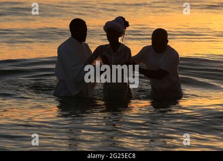 Miami-Sunny Isles-USA- 2-01-2016- une femme africaine est baptisée dans les eaux de la plage ensoleillée des îles à l'aube. © JOSE ISAAC BULA URRUITA. Banque D'Images