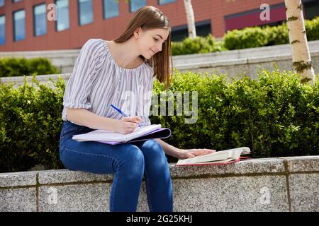 Jeune étudiante au collège travaillant à l'extérieur sur le campus du collège Banque D'Images