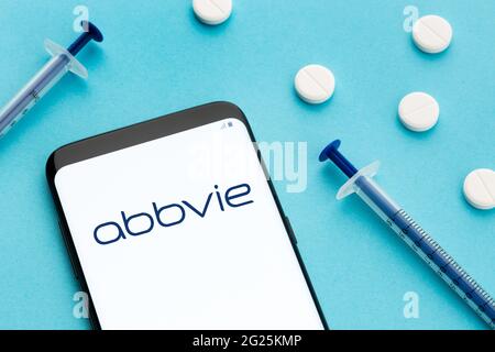 Galice, Espagne; 8 juin 2020 : smartphone montrant le logo Abbvie à l'écran et des pilules et une seringue sur fond bleu Banque D'Images