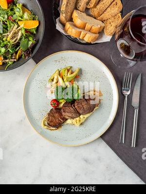 Filet de bœuf grillé sur une assiette en céramique avec beurre et thym. Recette de filet mignon avec légumes Banque D'Images