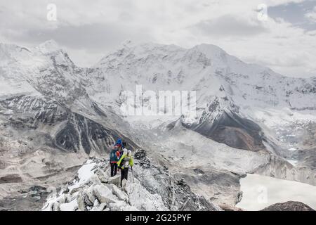 Une équipe d'alpinistes traverse une crête rocheuse sur Island Peak Banque D'Images