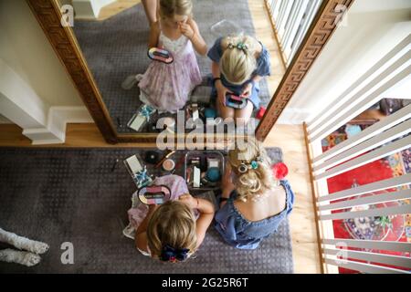 vue en hauteur des petites filles qui mettent du maquillage dans le miroir Banque D'Images