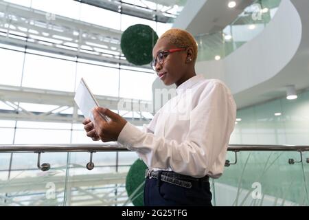 Un analyste afro-américain navigue sur une tablette près d'une rampe Banque D'Images