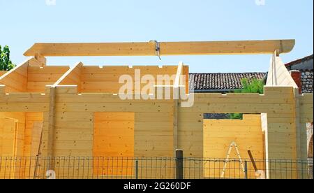 La poutre principale en position temporaire sur une maison de blocs préfabriqués en bois (sapin) partiellement construite sur un site de construction domestique à Friuli, en Italie Banque D'Images