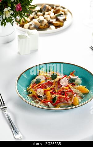 Ceviche de filet de poisson, poisson frais mariné au jus d'agrumes avec légumes frais et tranches d'orange, bar mariné. Banque D'Images