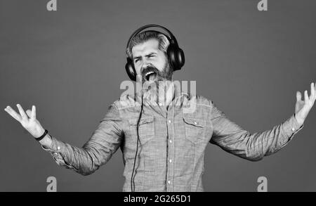 casque hipster homme barbu. Écouter de la musique. Il est temps de se détendre. Brutales vêtements hipster porter des écouteurs. Chant et danse. Profiter de sa musique préférée. Homme Banque D'Images