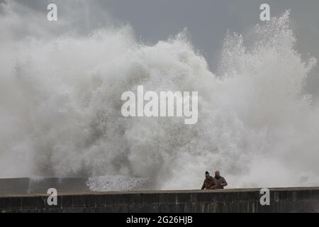 Porto, Portugal - 07 février 2016 : des gens intrépides dans le fleuve Douro, vieux quai nord pendant la tempête de la mer. Banque D'Images