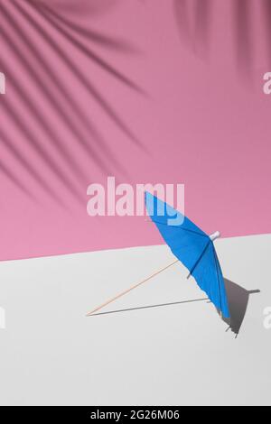 maquette d'été avec des couleurs pastel blanches et roses. plage bleue ou parasol à cocktail au soleil de midi et ombres dures des feuilles de palmier à l'arrière-plan pour Banque D'Images