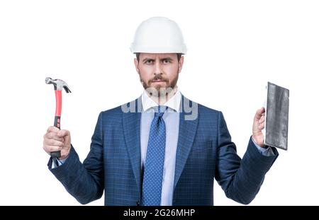 L'ingénieur du bâtiment porte un casque de sécurité avec une combinaison classique, un marteau et une truelle, une finition en plâtre Banque D'Images