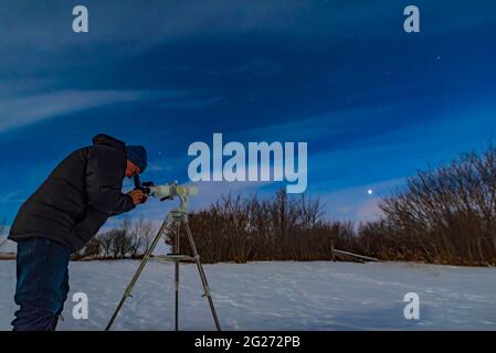 Astronome observant Vénus dans les nuages et au clair de lune. Banque D'Images