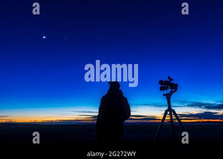 Un astronome regardant le croissant de lune cirant près de Vénus. Banque D'Images