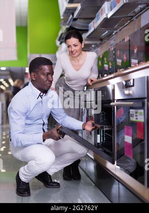 Le couple choisit un four de cuisine dans le magasin d'appareils ménagers Banque D'Images