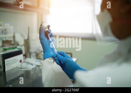 Le médecin tire un vaccin à seringue d'un flacon. Avant la vaccination pour construire l'immunité du corps contre le coronavirus. Banque D'Images