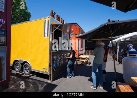 Les gens font la queue pendant le déjeuner au Corner 14 Foodcarts Spirits and Brew à Oregon City, Oregon, le jeudi 3 juin 2021. Banque D'Images