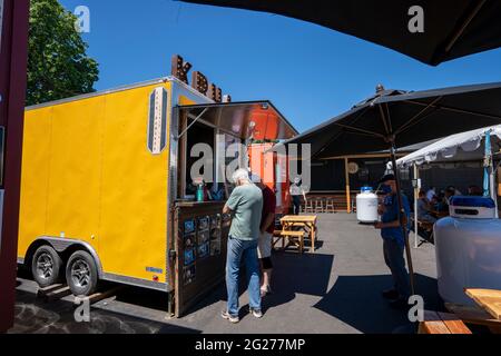 Les gens font la queue pendant le déjeuner au Corner 14 Foodcarts Spirits and Brew à Oregon City, Oregon, le jeudi 3 juin 2021. Banque D'Images