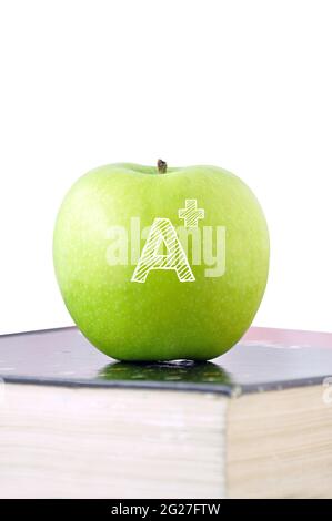 Pomme verte avec SIGNE A+ sur un manuel Banque D'Images