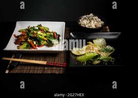 Cuisine végétarienne asiatique sur fond sombre vue de dessus. Emballez les légumes et le moule à riz pour faire sauter le choy sur une table noire Banque D'Images