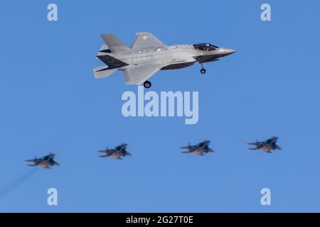 Une Air Force F-35A Lightning II des États-Unis s'élise au-dessus de quatre F-15E Strike Eagles. Banque D'Images