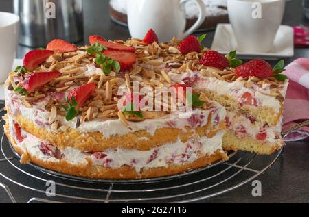 Gâteau entier à la crème de fraise sur une table à la maison. Vue en coupe Banque D'Images