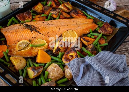 Repas de poisson méditerranéen avec légumes et patates douces servi sur une plaque de cuisson du dessus. Gros plan et vue isolée. Banque D'Images