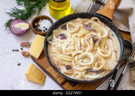 Régime de Keto, déjeuner. Le calmar est accompagné d'une sauce au fromage à la crème sure sur une table en pierre grise. Banque D'Images