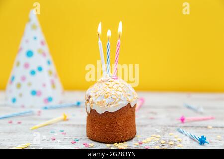 Gâteau de fête avec bougies sur fond jaune. Décorations pour un anniversaire ou des vacances. Mise au point sélective. Banque D'Images