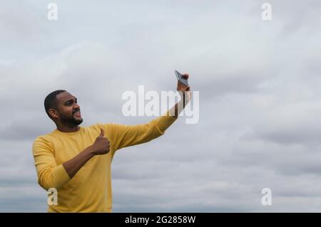 Jeune homme noir prenant un selfie et souriant à l'appareil photo Banque D'Images