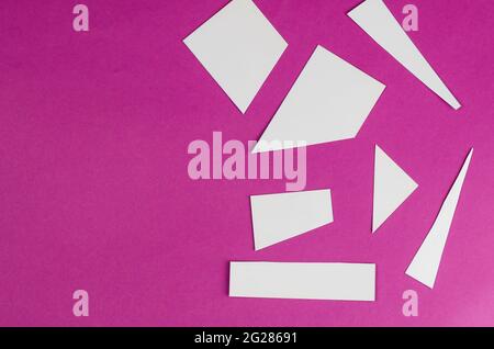 Formes géométriques blanches aléatoires sur rose. Trapèzes, rectangle, triangle. Vue de dessus. Copier l'espace Banque D'Images