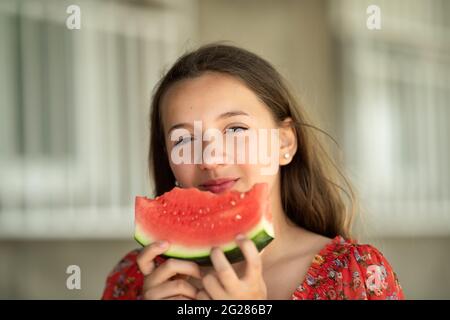 Portrait d'une jeune brunette petite fille avec le melon d'eau, piscine d'été. Banque D'Images