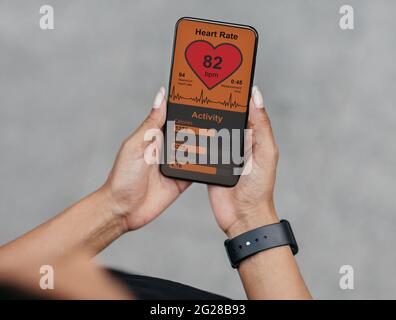 Femme noire sportive utilisant l'application mobile pendant l'entraînement Banque D'Images