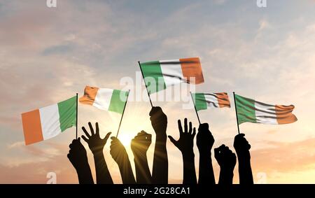 Silhouette de bras levés orgueillir d'un drapeau irlandais. Rendu 3D Banque D'Images
