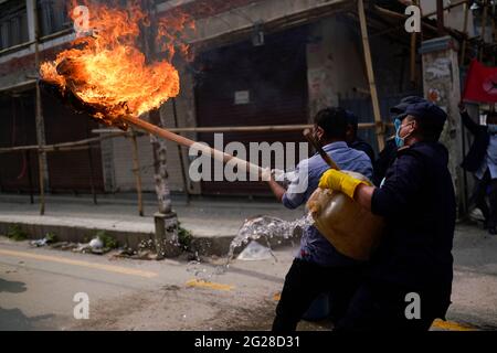 Katmandou, Népal. 9 juin 2021. Le personnel de police tente d'éveiller une effigie du Premier ministre du Népal, KP Sharma Oli, incendiée par l'alliance de l'opposition lors d'une manifestation contre la dissolution du Parlement, le remaniement ministériel et des élections anticipées dans le cadre du confinement de la pandémie du coronavirus à Katmandou, au Népal, le mercredi 9 juin 2021. Crédit: Skanda Gautam/ZUMA Wire/Alay Live News Banque D'Images